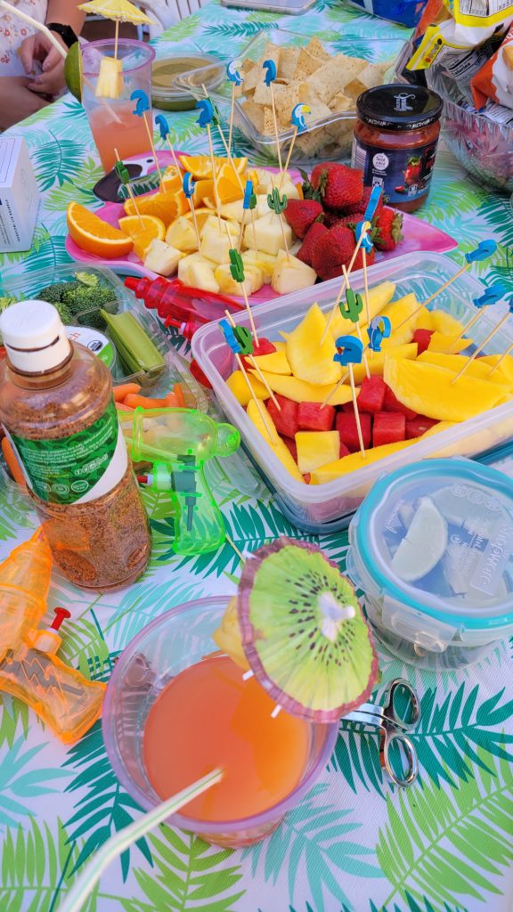 A table of pool party food like fruit, vegetables and snacks is all you need for you guests to dig in.